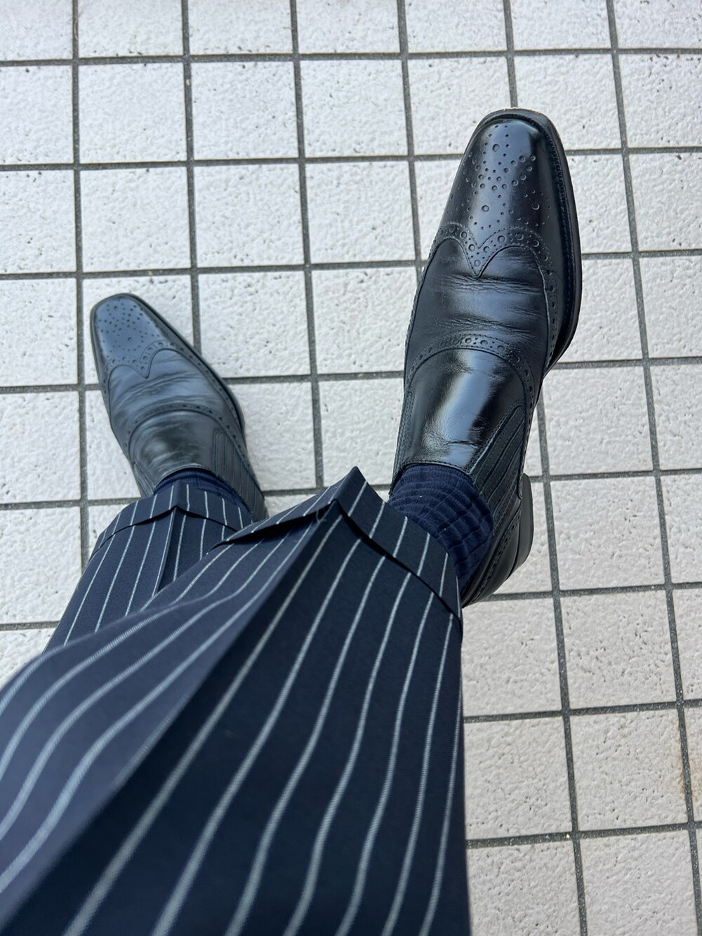 ホワイト系のビジネスシャツ、ブルー系のネクタイ、ホワイト系のポケットチーフを着用したメンズの春コーディネートの4枚目の写真