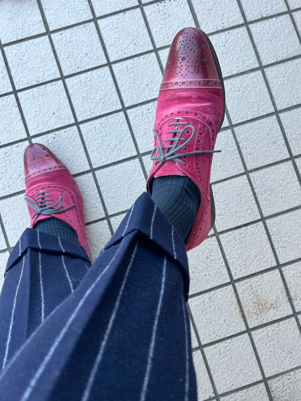 パープル系のビジネスシャツ、レッド系のネクタイ、レッド系のポケットチーフを着用したメンズの冬コーディネートの3枚目の写真