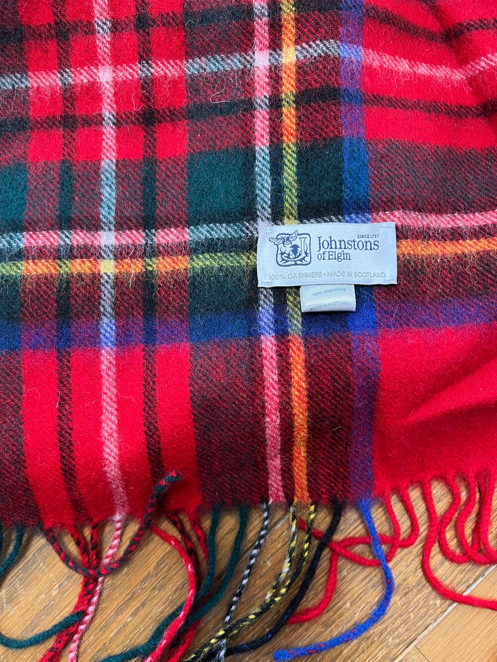 ベージュ系のステンカラーコート、レッド系のマフラーを着用したメンズの冬コーディネートの2枚目の写真