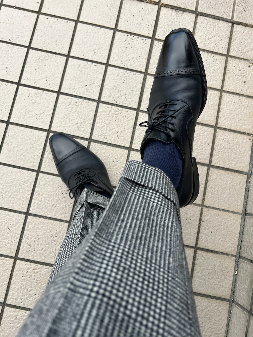 グレー系のスーツジャケット、ブルー系のネクタイ、ブルー系のポケットチーフを着用したメンズの秋コーディネートの4枚目の写真