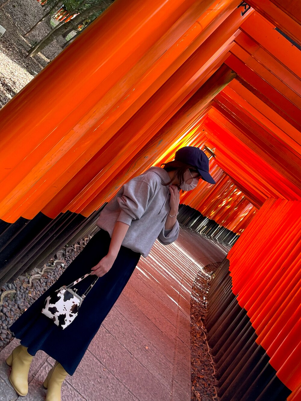 グレー系のパーカー、ブルー系のワンピース、ブルー系のキャップを着用したレディースの秋コーディネートの2枚目の写真