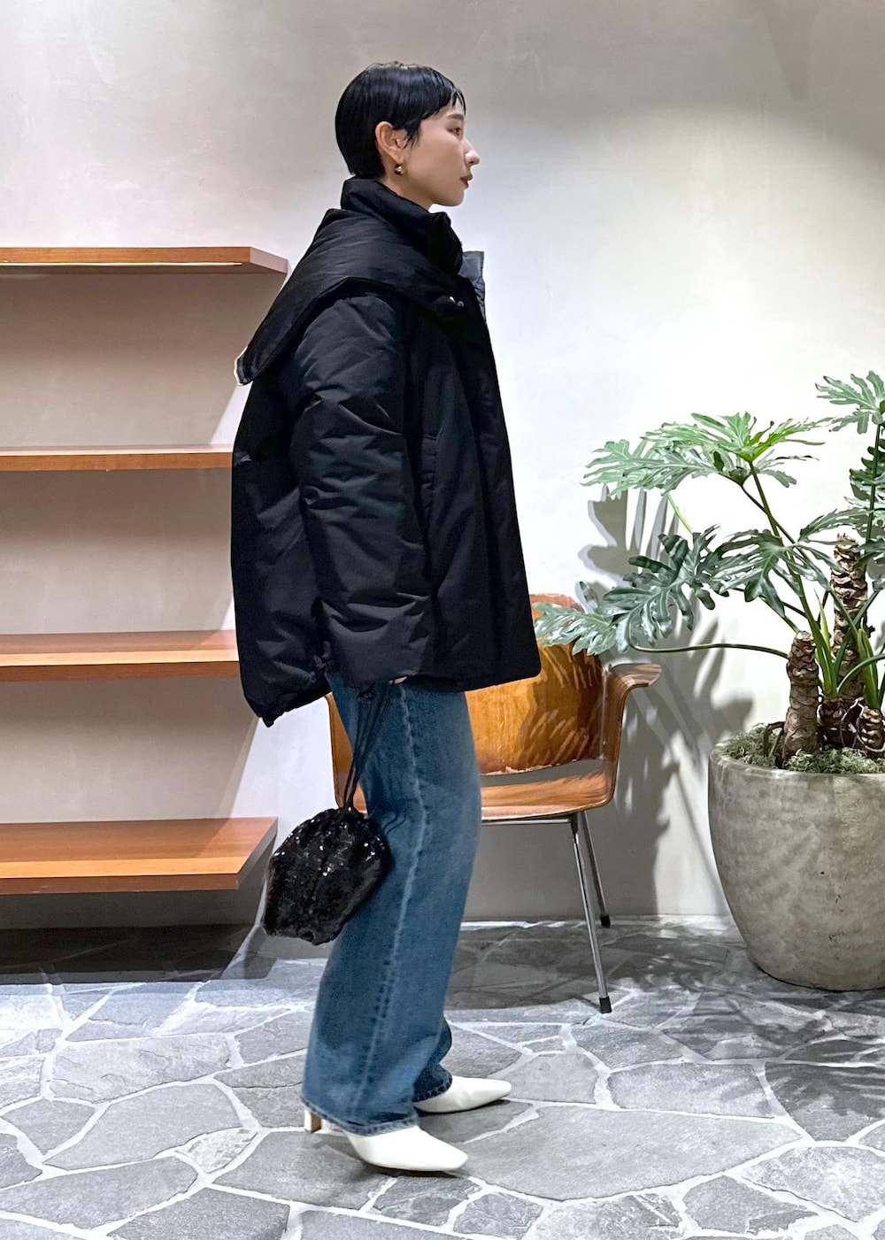 ホワイト系のブーツ、グレー系のカーディガン/ボレロ、ブラック系のダウンジャケット/コートを着用したレディースの冬コーディネートの2枚目の写真