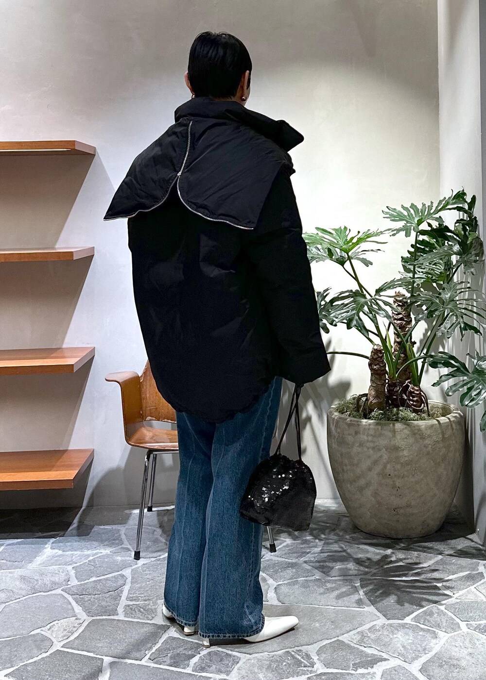 ホワイト系のブーツ、グレー系のカーディガン/ボレロ、ブラック系のダウンジャケット/コートを着用したレディースの冬コーディネートの3枚目の写真