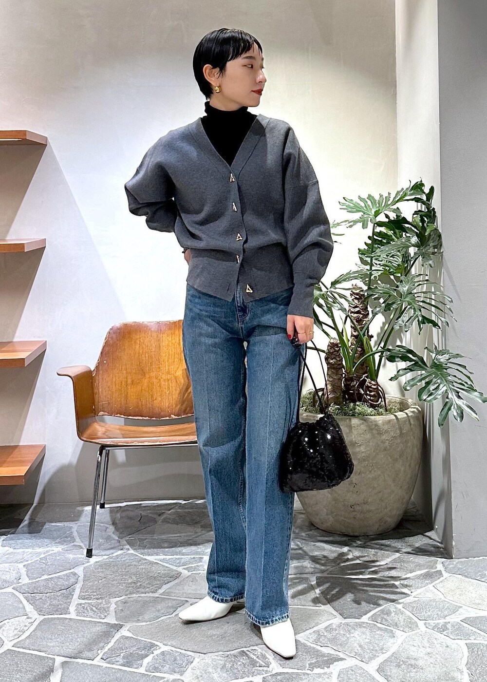 ホワイト系のブーツ、グレー系のカーディガン/ボレロ、ブラック系のダウンジャケット/コートを着用したレディースの冬コーディネートの5枚目の写真