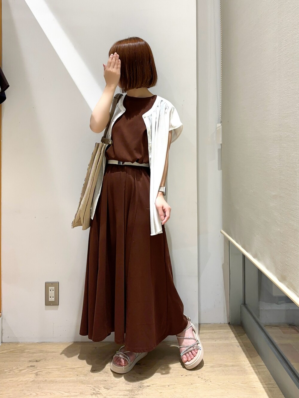 ホワイト系のシャツ/ブラウス、ブラウン系のワンピース、ベージュ系のサンダルを着用したレディースの夏コーディネートの2枚目の写真