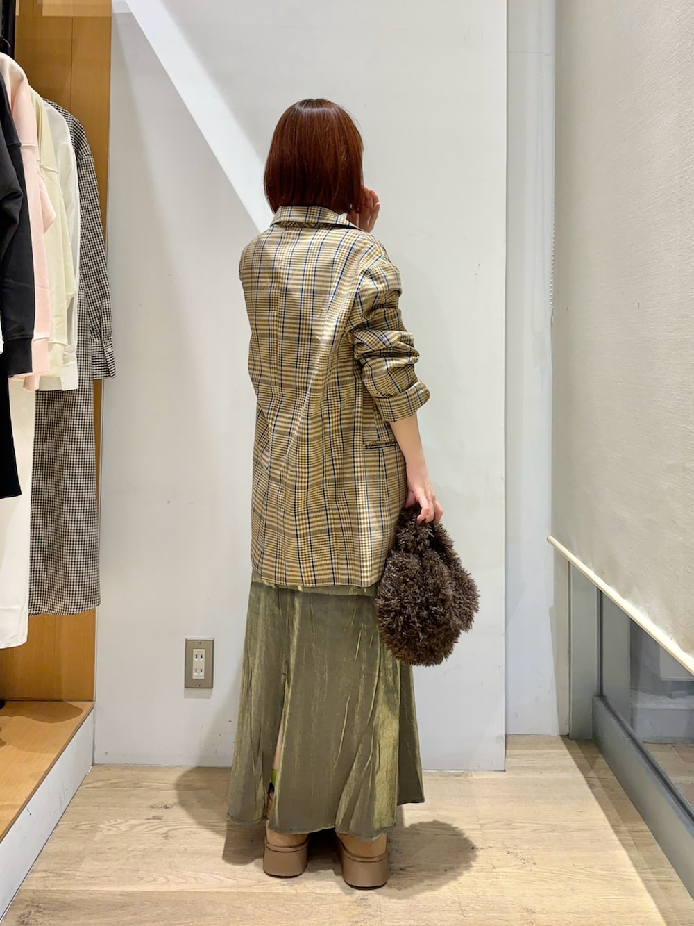 ホワイト系のニット/セーター、ブラウン系のノーカラージャケット、グリーン系のスカートを着用したレディースの秋コーディネートの3枚目の写真