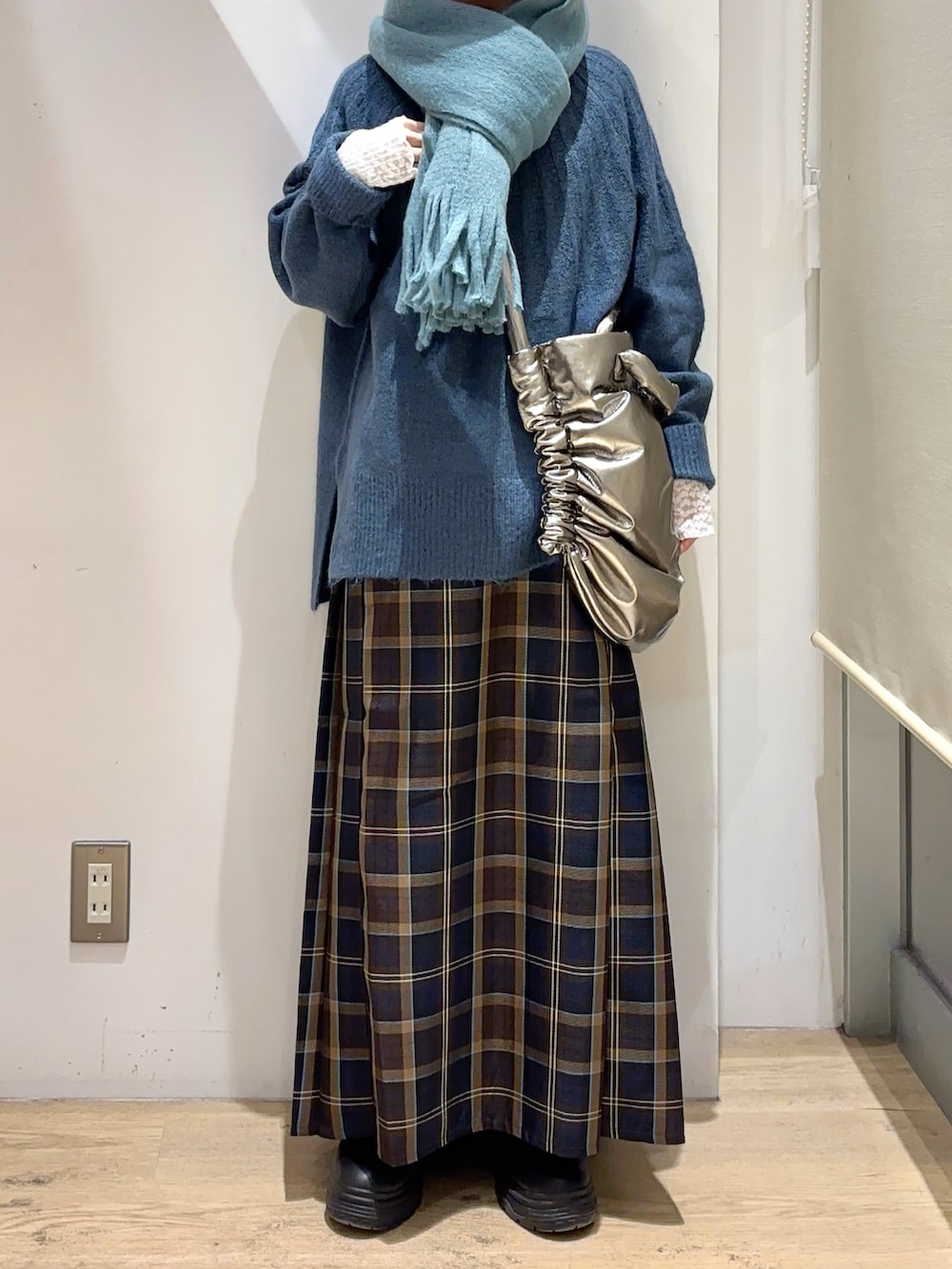 シルバー系のハンドバッグ、ブルー系のニット/セーター、ブラウン系のスカートを着用したレディースの秋コーディネートの4枚目の写真