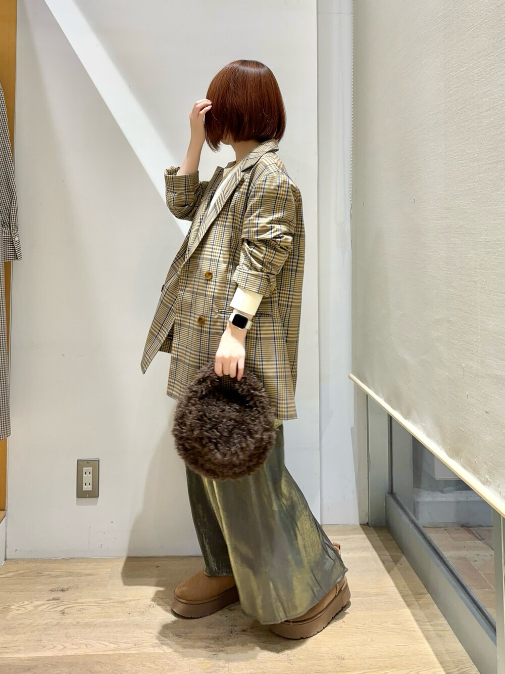 ホワイト系のニット/セーター、ブラウン系のノーカラージャケット、グリーン系のスカートを着用したレディースの秋コーディネートの2枚目の写真