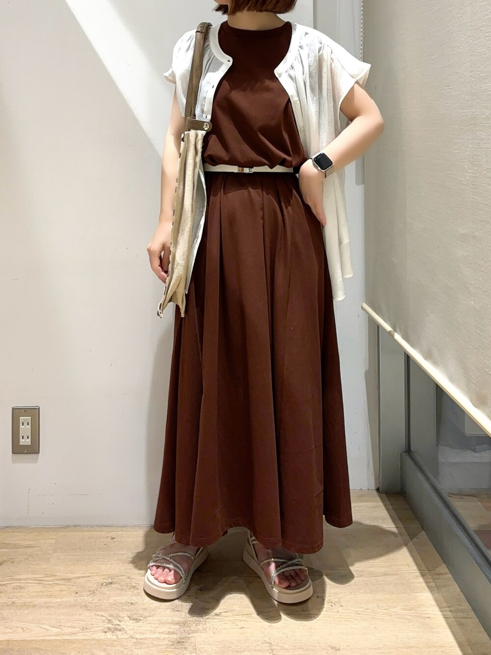 ホワイト系のシャツ/ブラウス、ブラウン系のワンピース、ベージュ系のサンダルを着用したレディースの夏コーディネートの3枚目の写真