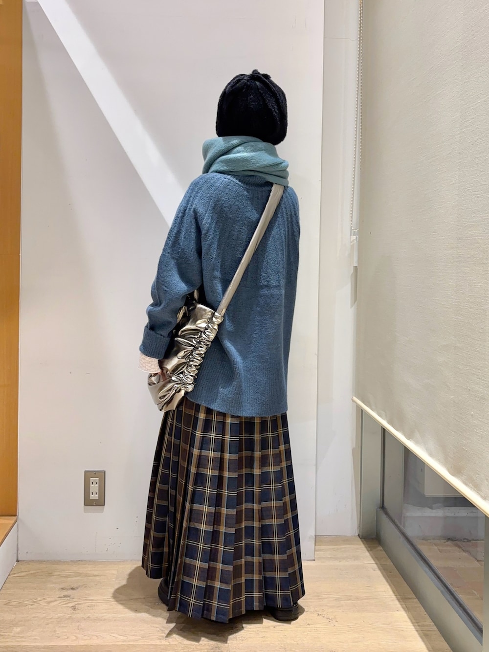 シルバー系のハンドバッグ、ブルー系のニット/セーター、ブラウン系のスカートを着用したレディースの秋コーディネートの3枚目の写真