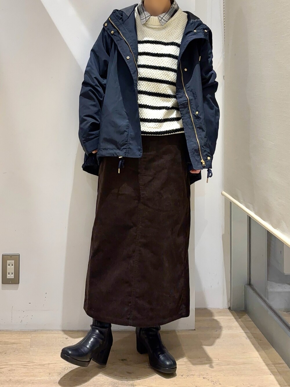 ブラック系のシャツ/ブラウス、ホワイト系のニット/セーター、ブラウン系のスカートを着用したレディースの秋コーディネートの3枚目の写真