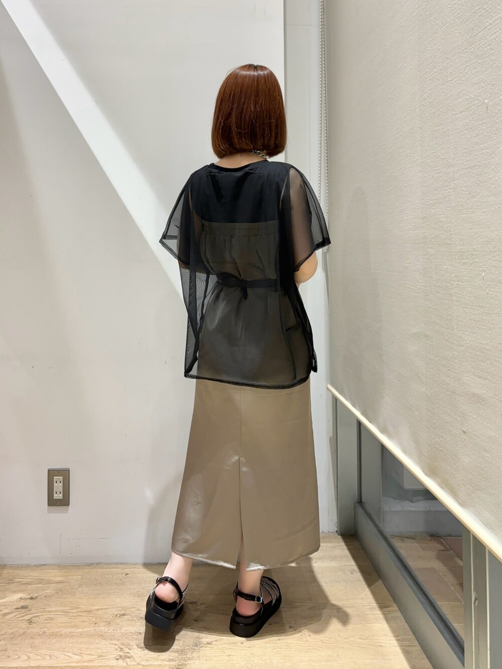 ブラック系のTシャツ/カットソー、ブラウン系のスカート、ブラック系のサンダルを着用したレディースの夏コーディネートの2枚目の写真