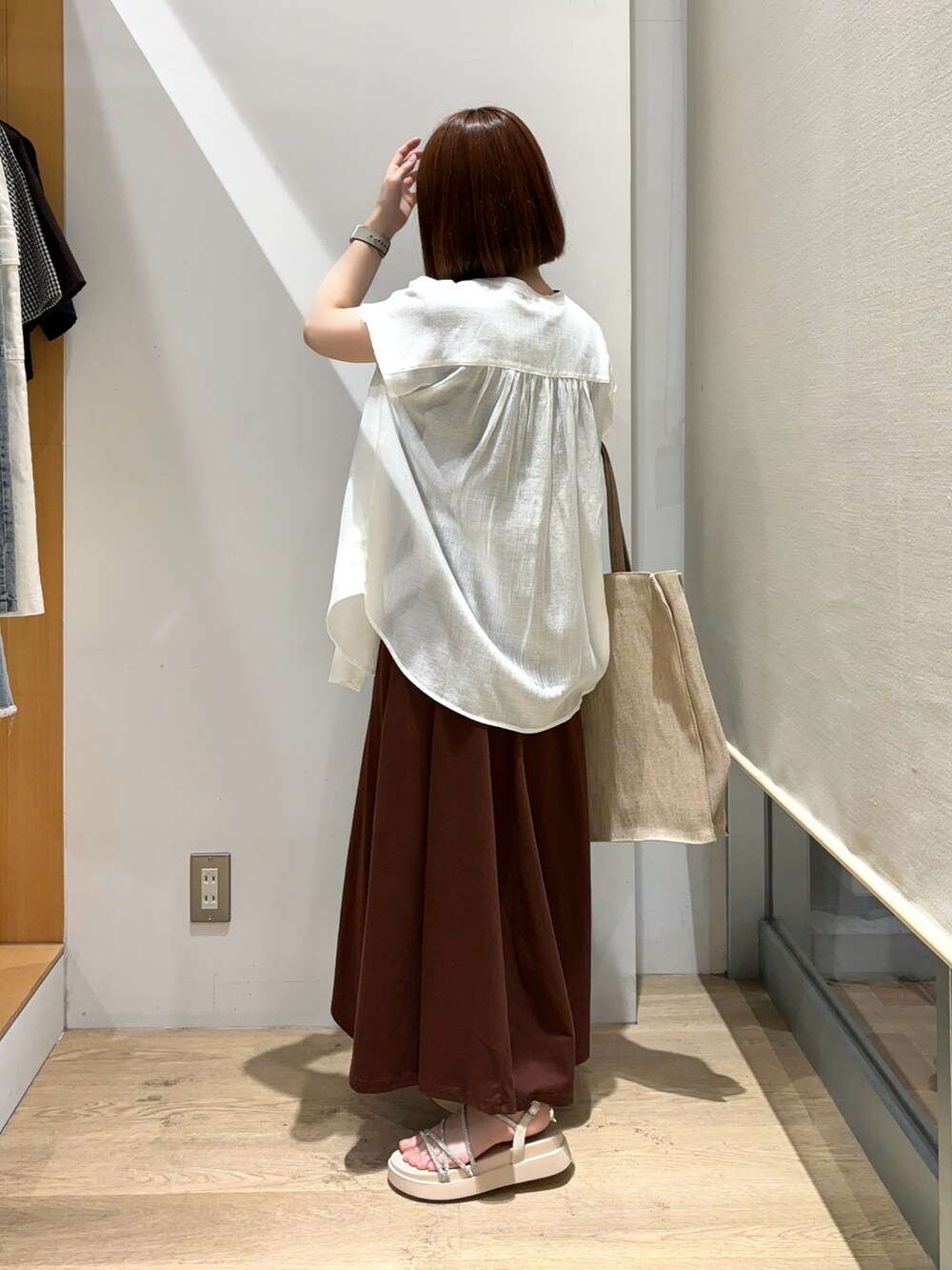 ホワイト系のシャツ/ブラウス、ブラウン系のワンピース、ベージュ系のサンダルを着用したレディースの夏コーディネートの4枚目の写真
