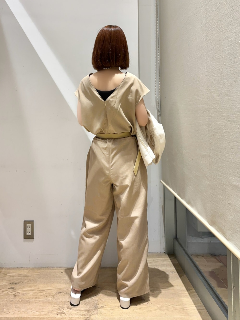 ベージュ系のサロペット/オーバーオール、ホワイト系のノーカラージャケット、ホワイト系のハンドバッグを着用したレディースの夏コーディネートの3枚目の写真
