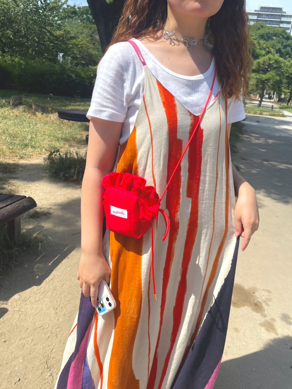 オレンジ系のワンピース、ホワイト系のTシャツ/カットソー、ブラック系のその他シューズを着用したレディースの秋コーディネートの2枚目の写真