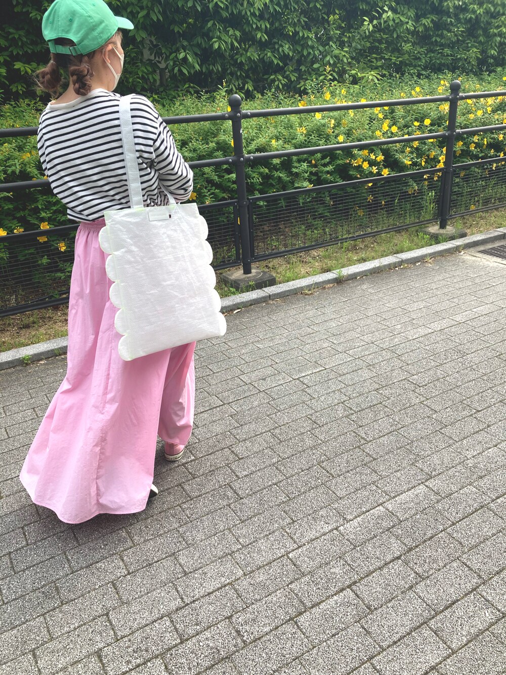 ホワイト系のトップス、ピンク系のスカート、ピンク系のスニーカーを着用したレディースの夏コーディネートの2枚目の写真