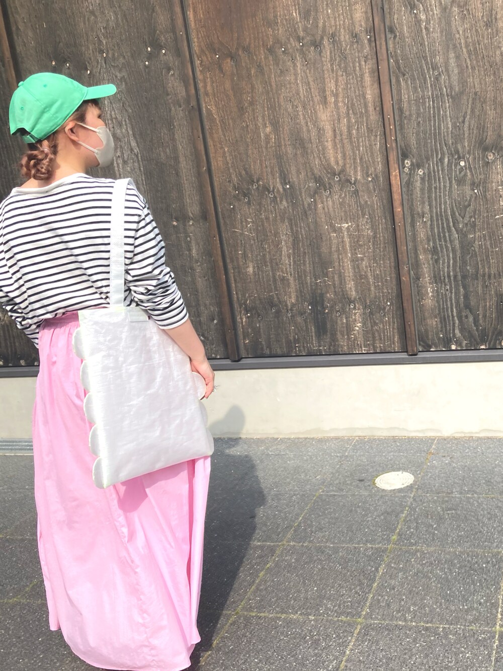 ホワイト系のトップス、ピンク系のスカート、ピンク系のスニーカーを着用したレディースの夏コーディネートの3枚目の写真