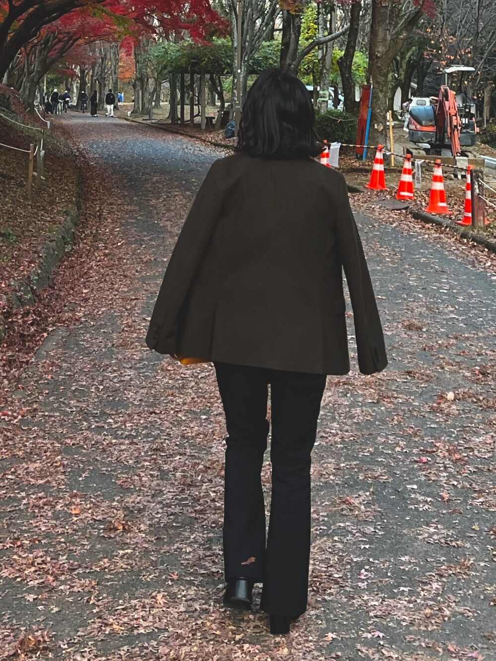 イエロー系のトートバッグ、ブラック系のその他パンツ、ブラック系のブーツを着用したレディースの冬コーディネートの2枚目の写真