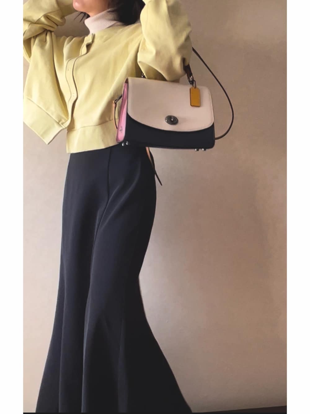 オレンジ系のカーディガン/ボレロ、ホワイト系のニット/セーター、その他のショルダーバッグを着用したレディースの春コーディネートの2枚目の写真