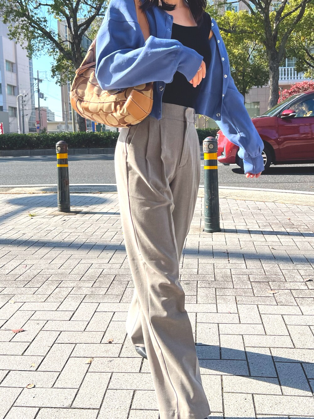 ブラック系のトップス、ブルー系のカーディガン/ボレロ、ブラウン系のパンツを着用したレディースの秋コーディネートの4枚目の写真