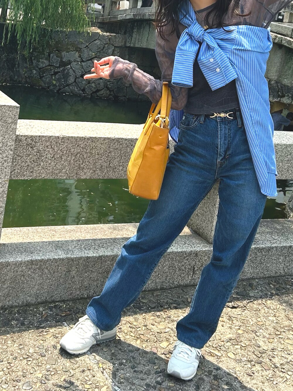 イエロー系のトートバッグ、ブルー系のシャツ/ブラウス、グレー系のTシャツ/カットソーを着用したレディースの春コーディネートの3枚目の写真