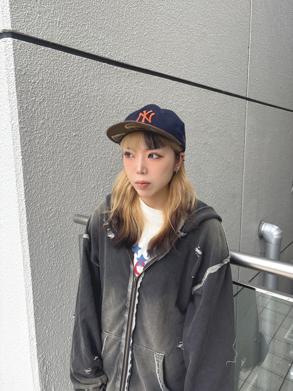 ブラック系のパーカー、ブルー系のデニムパンツ、ブラック系のスニーカーを着用したレディースの秋コーディネートの2枚目の写真