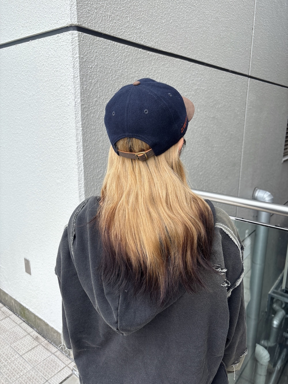 ブラック系のパーカー、ブルー系のデニムパンツ、ブラック系のスニーカーを着用したレディースの秋コーディネートの4枚目の写真