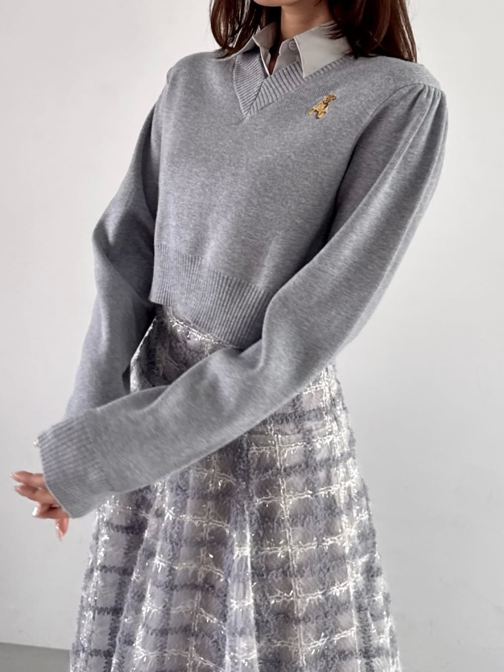 グレー系のニット/セーター、パープル系のスカートを着用したレディースの秋コーディネートの9枚目の写真