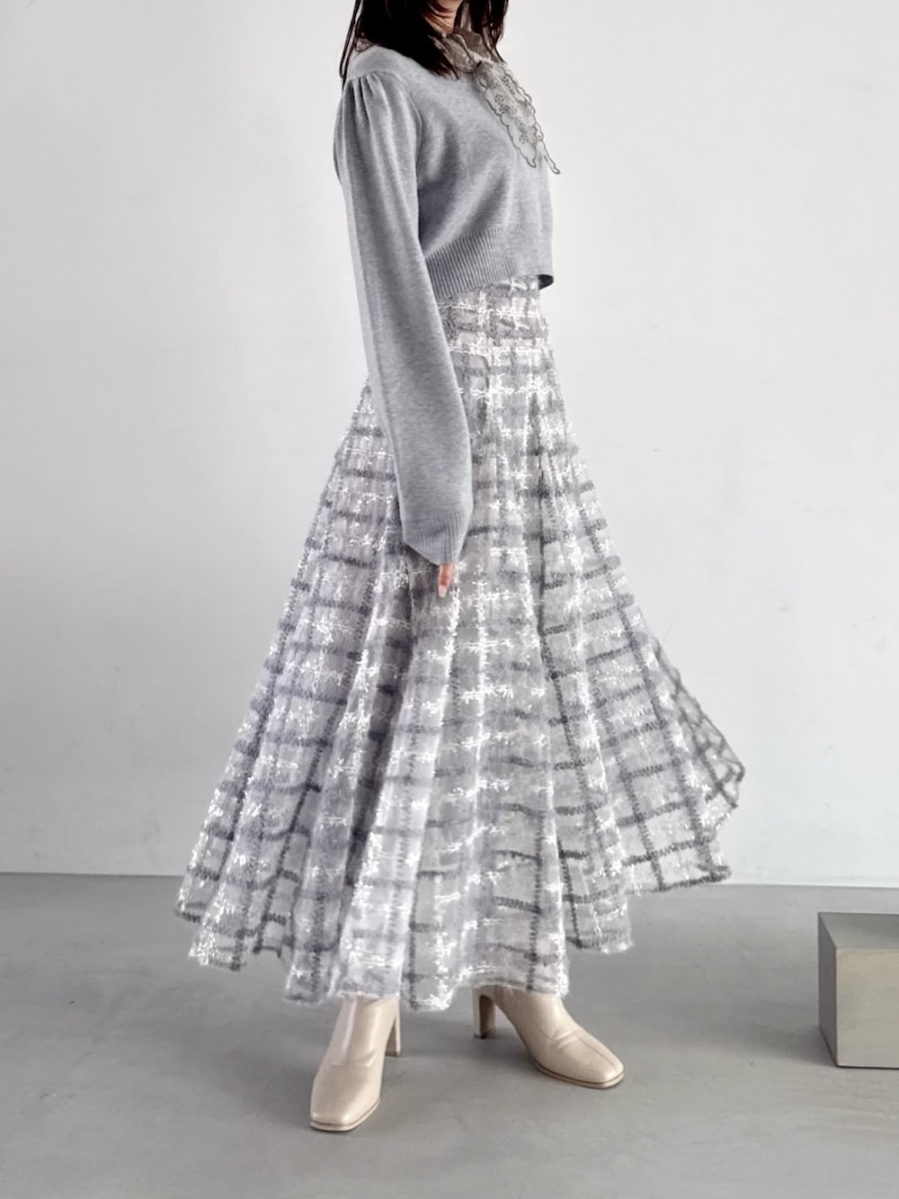 グレー系のニット/セーター、パープル系のスカートを着用したレディースの秋コーディネートの4枚目の写真