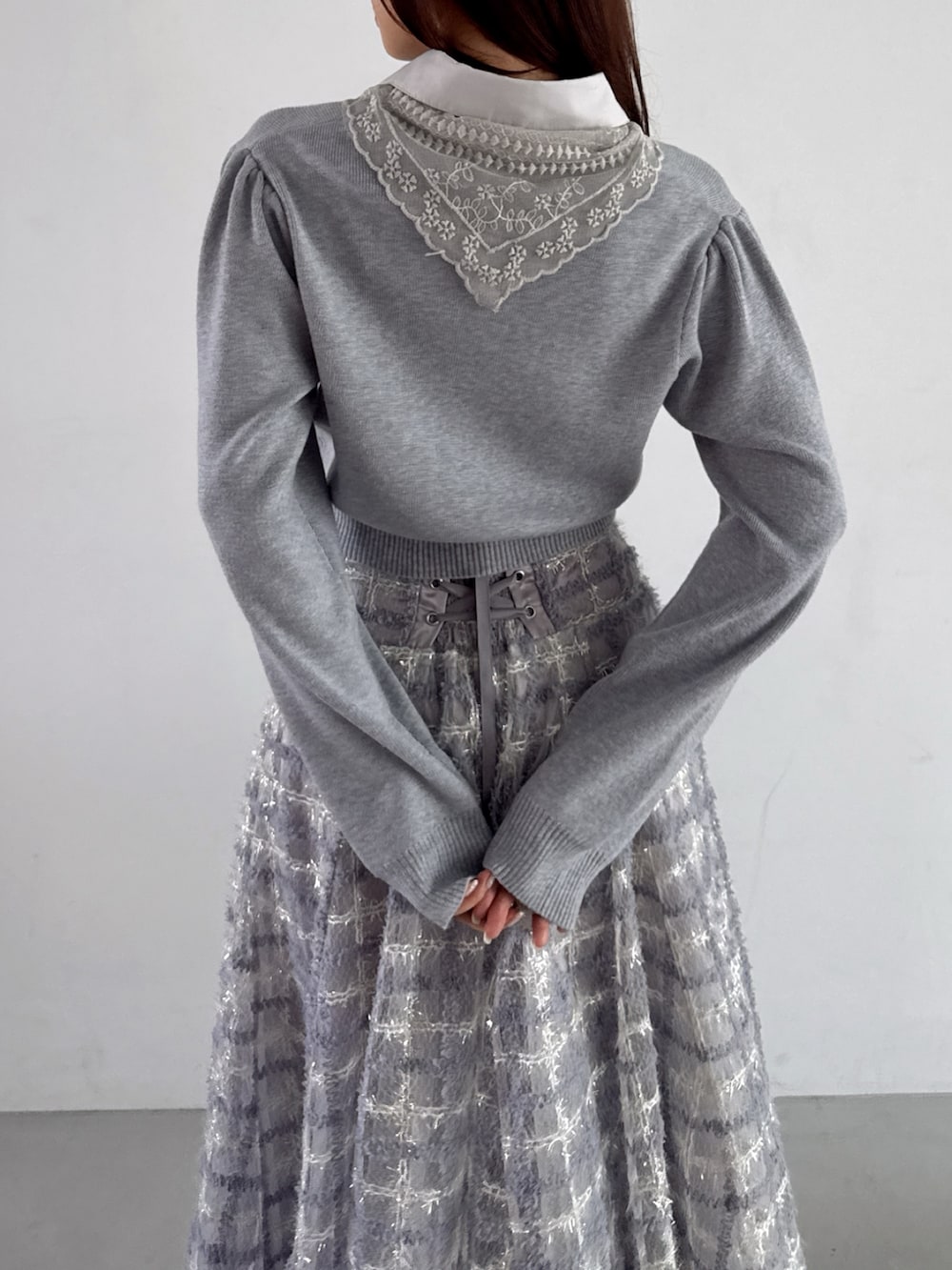 グレー系のニット/セーター、パープル系のスカートを着用したレディースの秋コーディネートの7枚目の写真