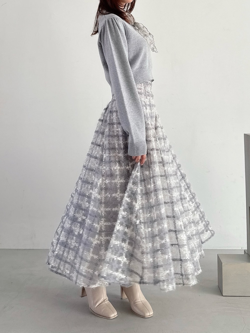 グレー系のニット/セーター、パープル系のスカートを着用したレディースの秋コーディネートの8枚目の写真