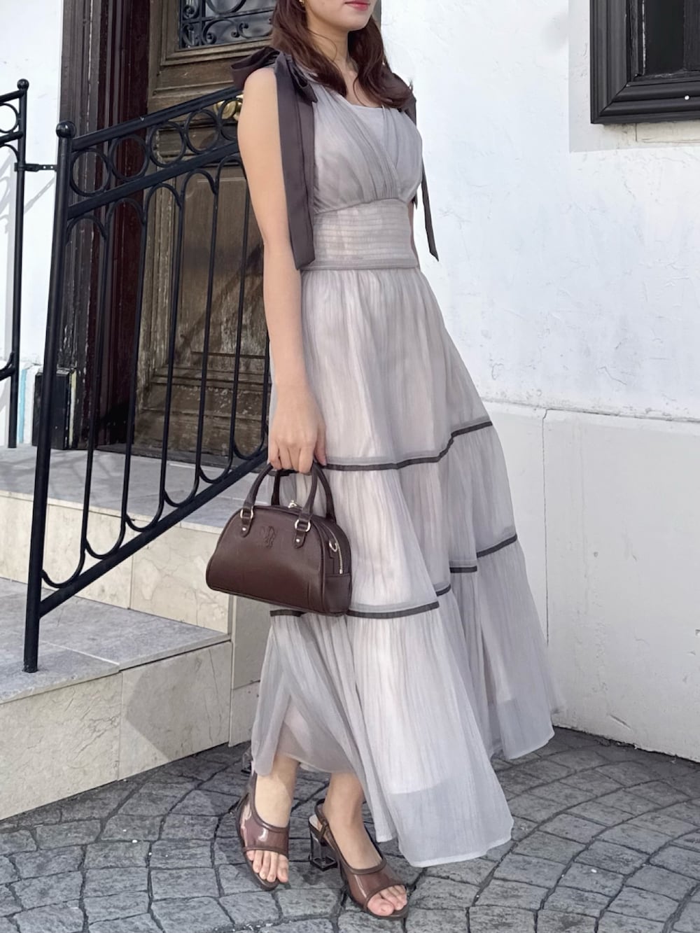 ベージュ系のワンピースを着用したレディースの春コーディネートの2枚目の写真