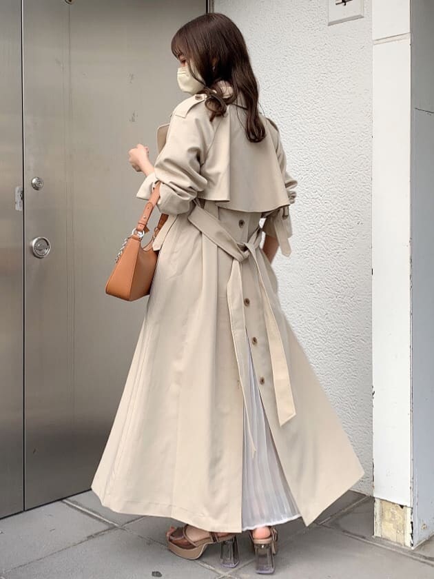 ピンク系のワンピース、ベージュ系のトレンチコート、ブラウン系のサンダルを着用したレディースの春コーディネートの4枚目の写真