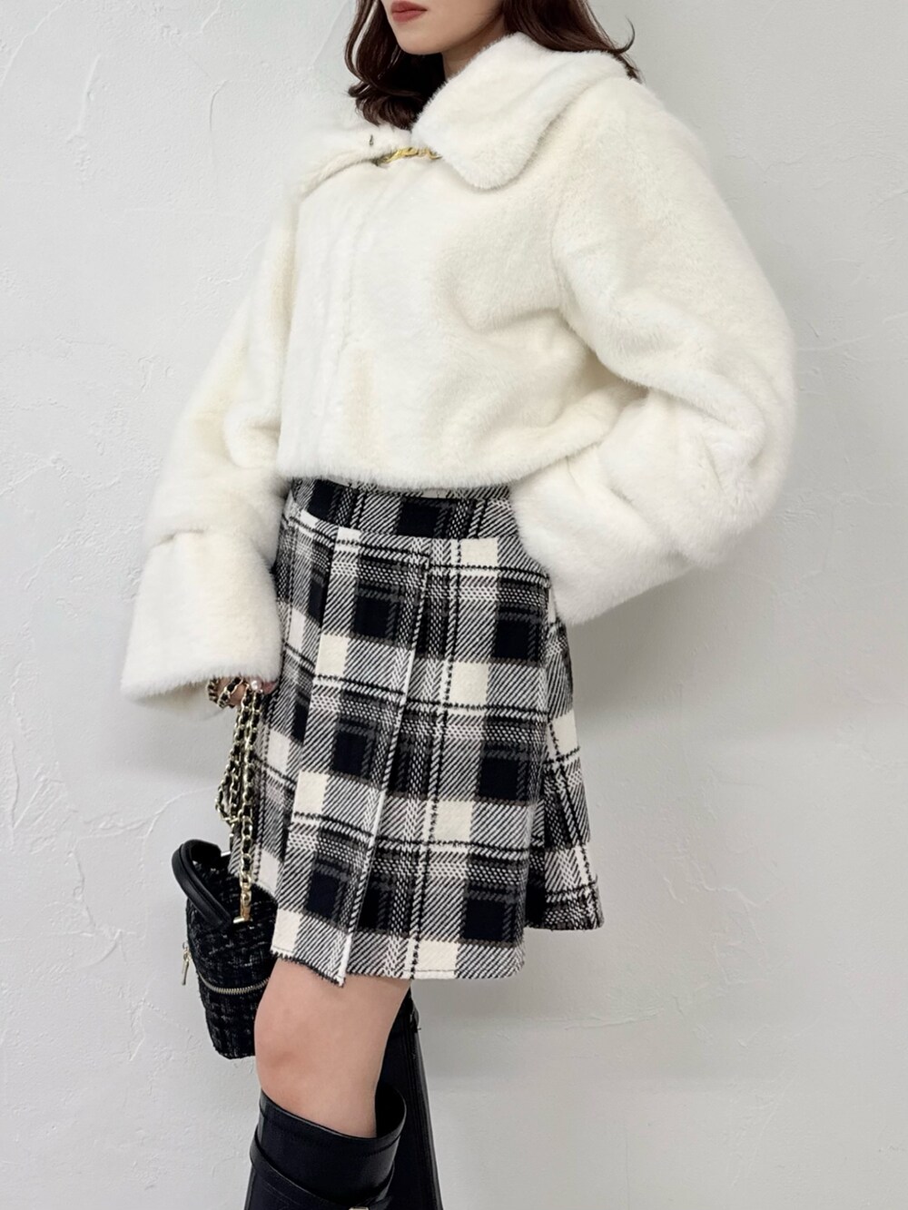 ホワイト系のその他アウター、ブラック系のスカート、ブラック系のブーツを着用したレディースの冬コーディネートの8枚目の写真