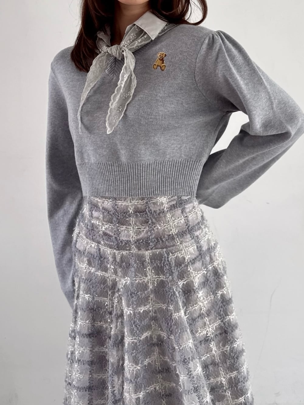 グレー系のニット/セーター、パープル系のスカートを着用したレディースの秋コーディネートの5枚目の写真