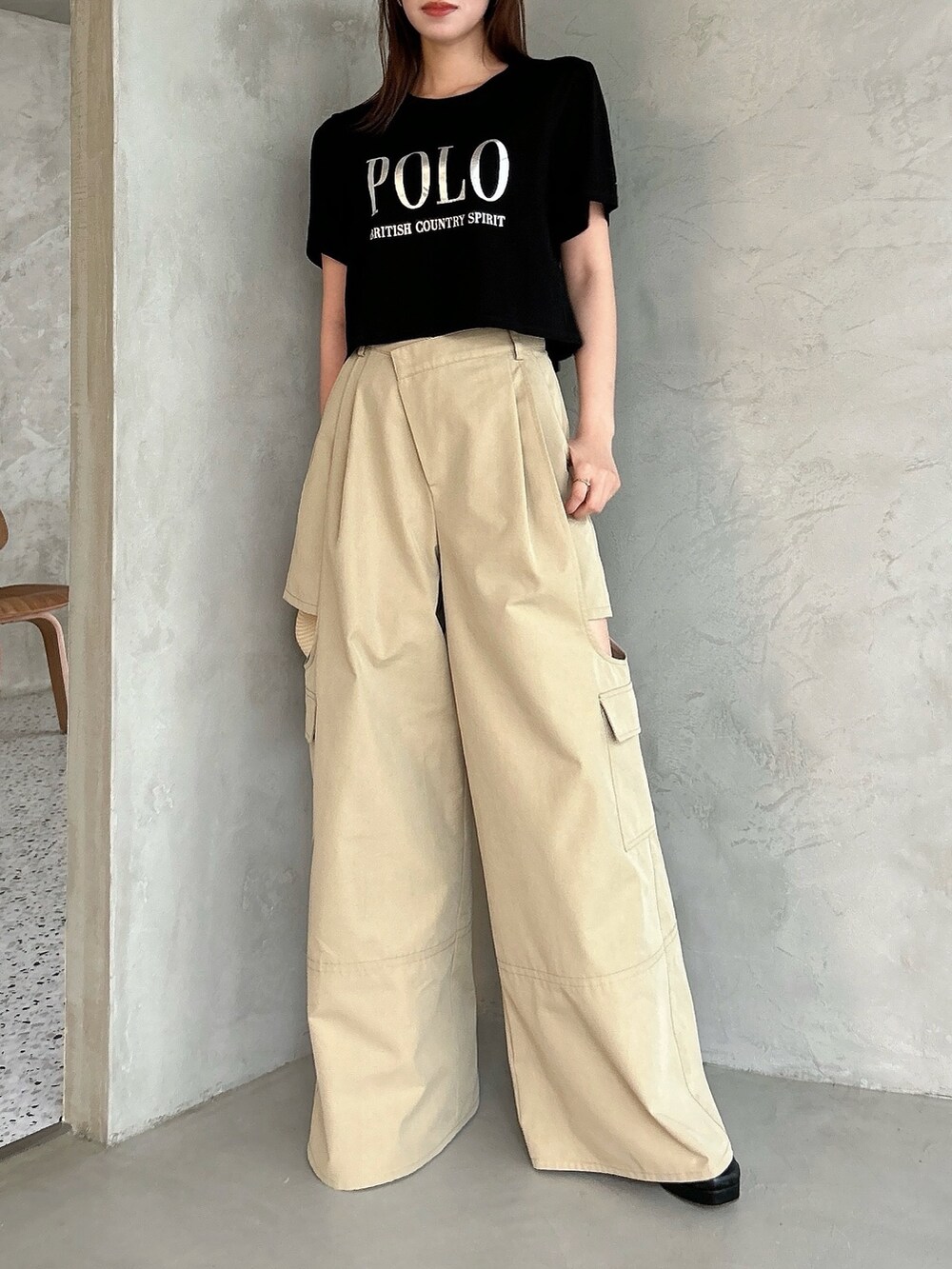 ベージュ系のチノパンツ、ブラック系のTシャツ/カットソー、ブラック系のTシャツ/カットソーを着用したレディースの春コーディネートの6枚目の写真