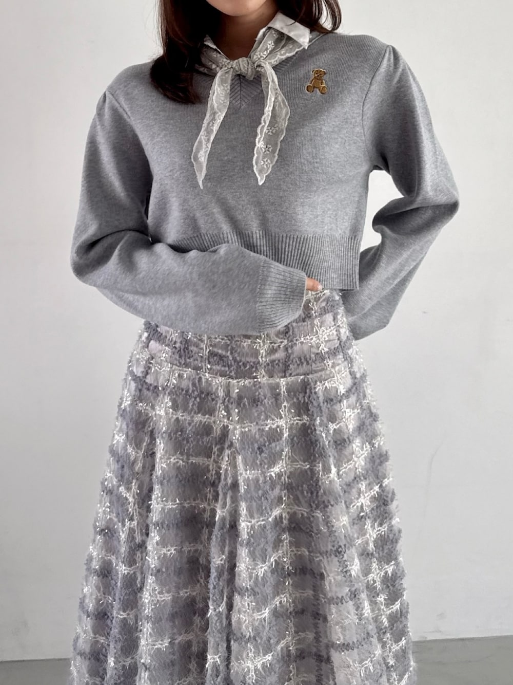 グレー系のニット/セーター、パープル系のスカートを着用したレディースの秋コーディネートの6枚目の写真