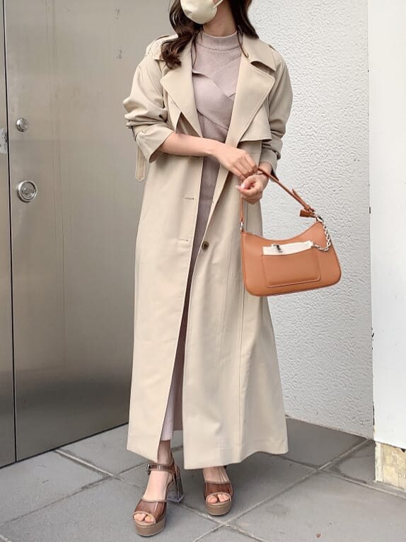 ピンク系のワンピース、ベージュ系のトレンチコート、ブラウン系のサンダルを着用したレディースの春コーディネートの2枚目の写真