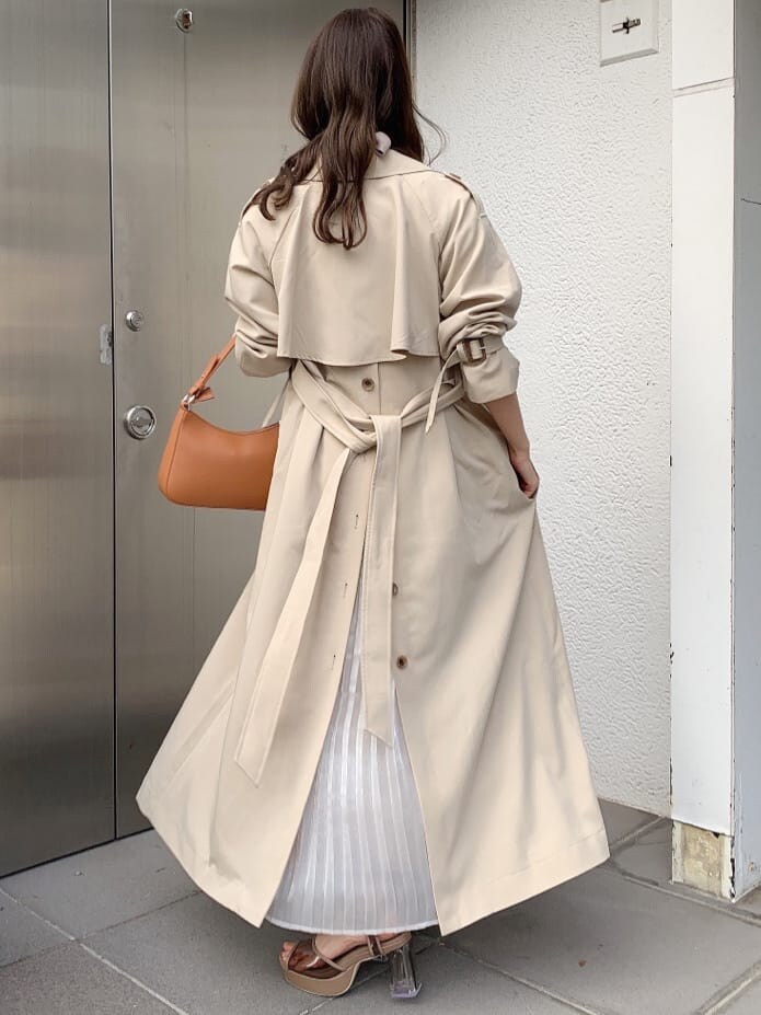 ピンク系のワンピース、ベージュ系のトレンチコート、ブラウン系のサンダルを着用したレディースの春コーディネートの3枚目の写真