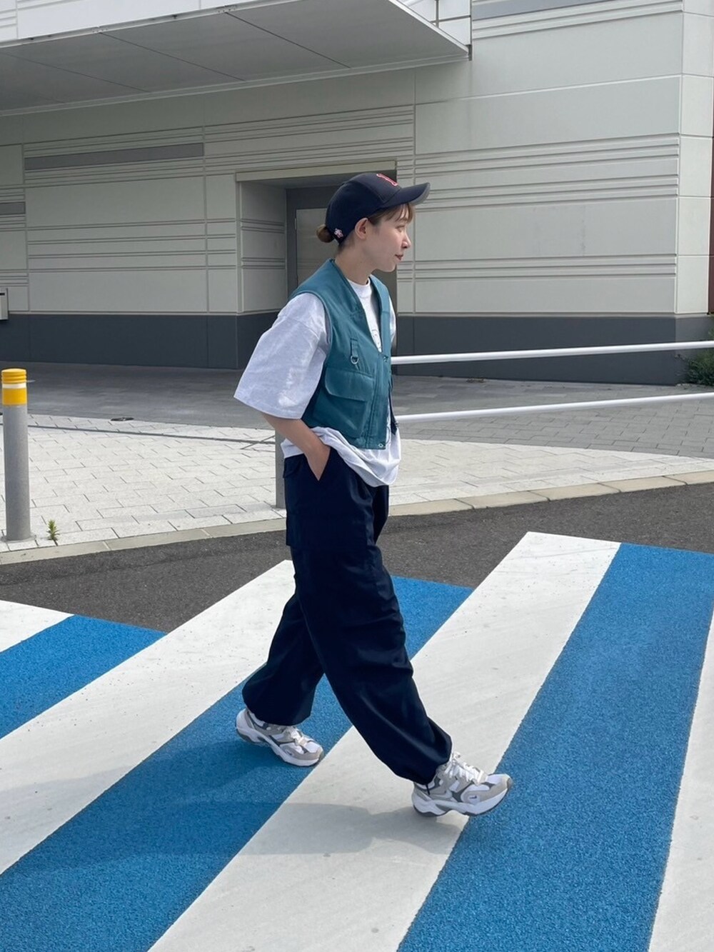 グレー系のTシャツ/カットソー、ブルー系のベスト、ブルー系のカーゴパンツを着用したレディースの夏コーディネートの2枚目の写真