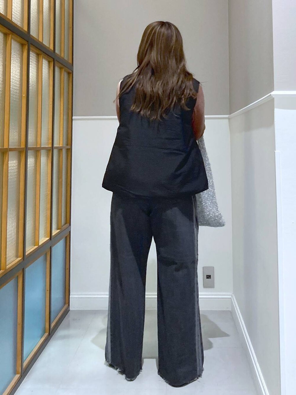 ブラック系のベスト、ピンク系のTシャツ/カットソー、シルバー系のショルダーバッグを着用したレディースの秋コーディネートの3枚目の写真