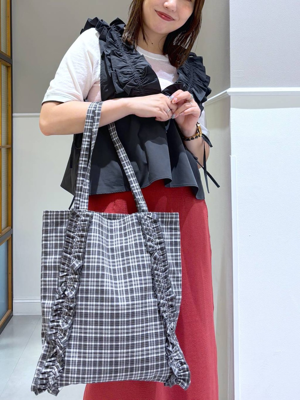 レッド系のスカート、ブラック系のトートバッグ、ブラウン系のサンダルを着用したレディースの夏コーディネートの4枚目の写真