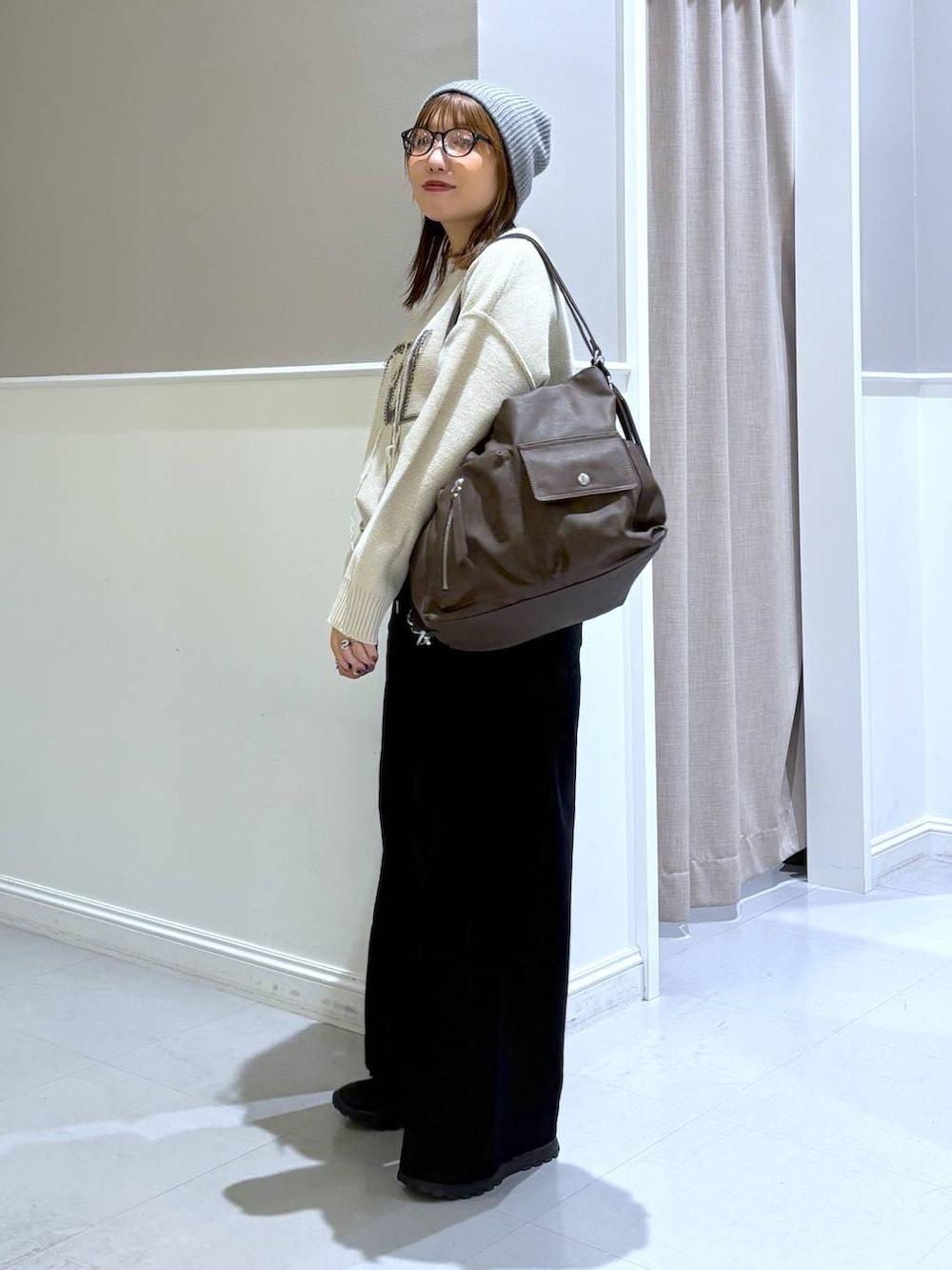 ブラック系のその他パンツ、ブラック系のその他シューズ、ブラウン系のショルダーバッグを着用したレディースの秋コーディネートの2枚目の写真