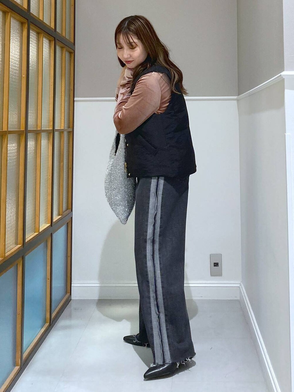 ブラック系のベスト、ピンク系のTシャツ/カットソー、シルバー系のショルダーバッグを着用したレディースの秋コーディネートの2枚目の写真