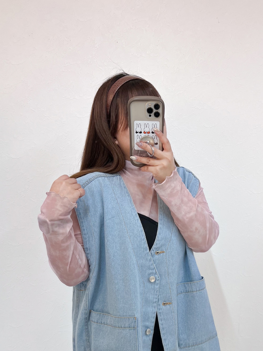 ブルー系のベスト、ブラック系のワンピース、ブラック系のブーツを着用したレディースの春コーディネートの3枚目の写真