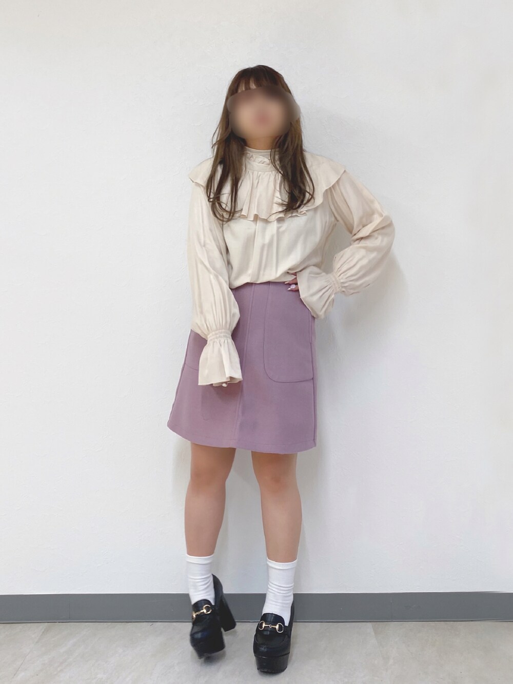 ベージュ系のベスト、ピンク系のスカート、ブラック系のシューズを着用したレディースの冬コーディネートの2枚目の写真