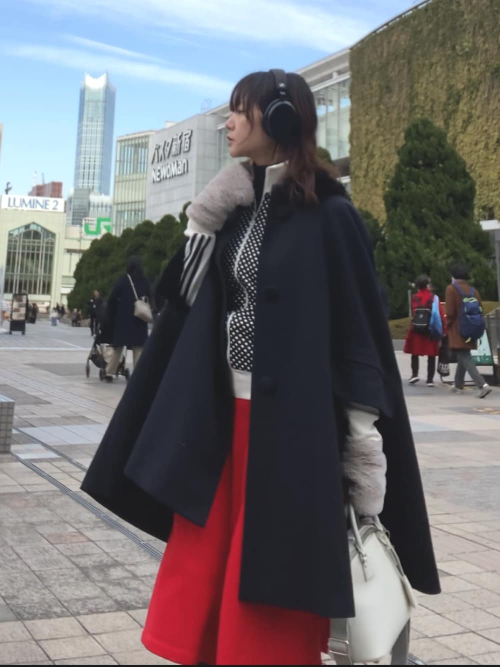 グレー系のショルダーバッグ、ブラック系のブーツ、ブルー系のジャケット/アウターを着用したレディースの冬コーディネートの2枚目の写真