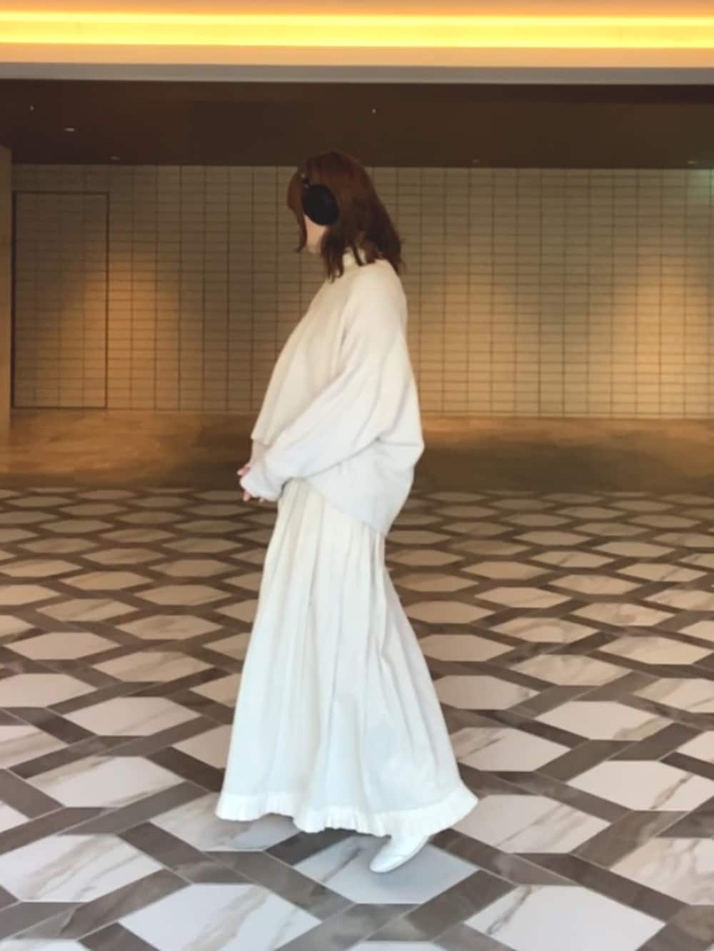 ブラック系のジャケット/アウター、ホワイト系のニット/セーター、ホワイト系のスカートを着用したレディースの冬コーディネートの3枚目の写真