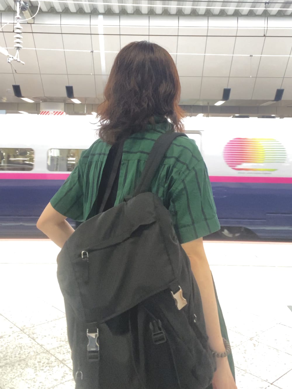 グリーン系のワンピース/ドレス、ブラック系のスカート、ブラック系のスニーカーを着用したレディースの秋コーディネートの2枚目の写真