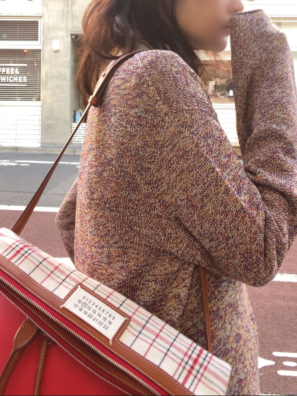 その他のニット/セーター、グレー系のスラックス、レッド系のバッグを着用したレディースの冬コーディネートの2枚目の写真